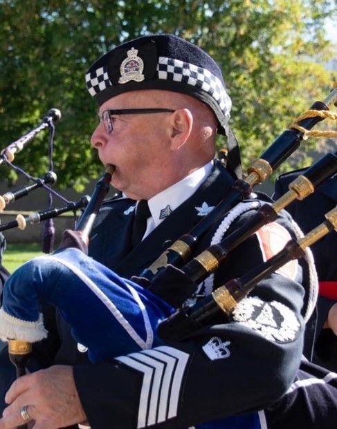 Pipe Major Lorne Clifford in a parade playing the bagpipes